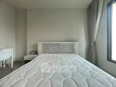 Modern bedroom with minimalist design and large window for natural light.