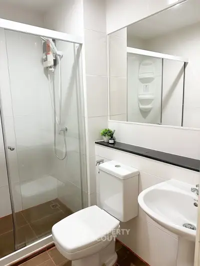 Modern bathroom with glass shower enclosure and sleek fixtures