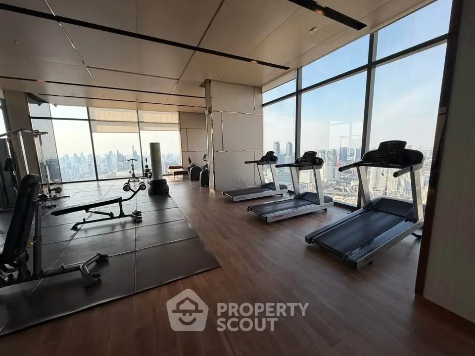 Luxurious high-rise gym with panoramic city views and modern fitness equipment.