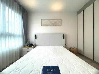 Modern bedroom with large window and stylish decor in a cozy apartment.