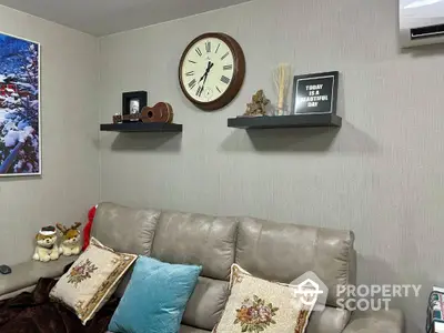 Cozy living room with decorative shelves and plush sofa, perfect for relaxation.