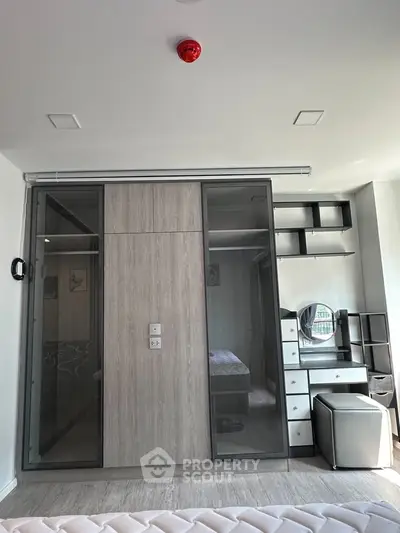 Modern bedroom with sliding glass wardrobe and stylish vanity area