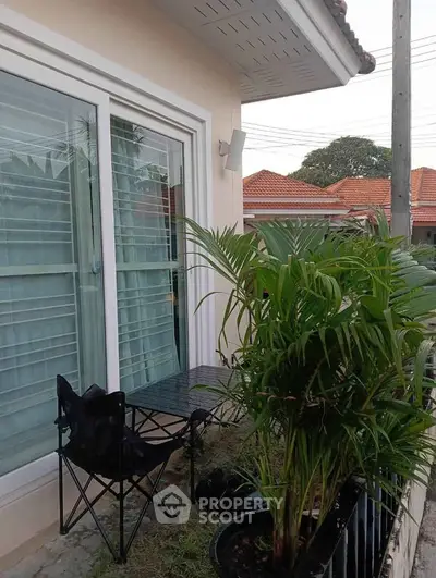Charming small balcony with lush greenery and cozy seating area.