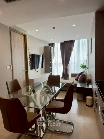 Modern living room with glass dining table and stylish decor in a high-rise apartment.