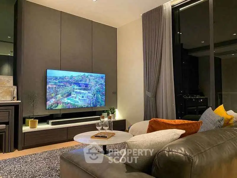Luxurious living room with modern decor and large TV, perfect for relaxation.