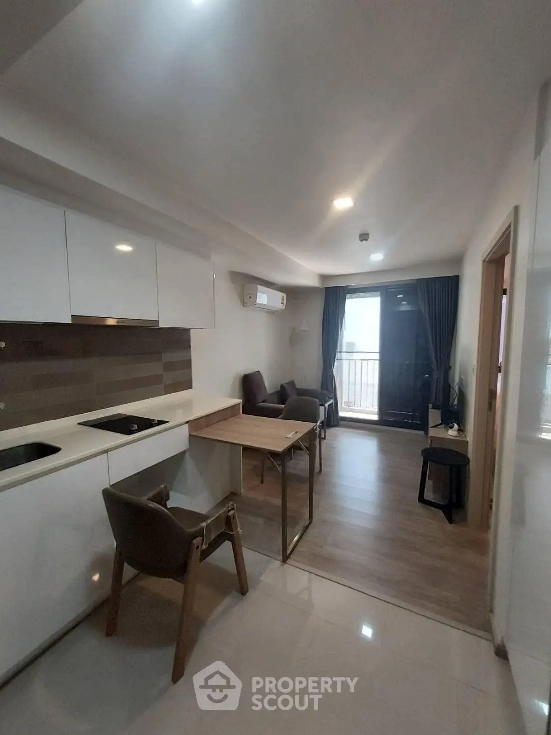 Modern open-plan kitchen and living area with sleek design and balcony access.