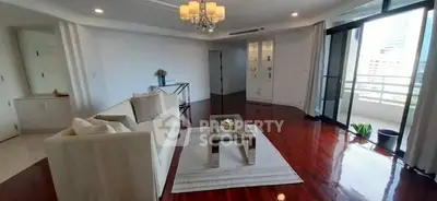 Spacious living room with elegant decor and large windows offering city views.