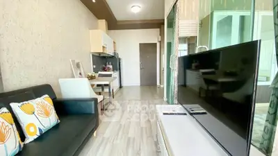 Modern open-layout living room with stylish decor and compact kitchen area.