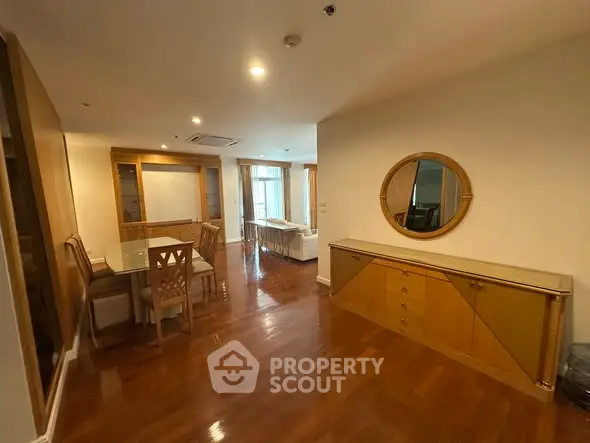 Spacious dining and living area with elegant wooden flooring and modern furniture.