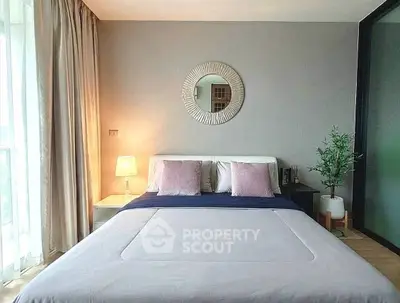 Modern bedroom with stylish decor and natural light, featuring a cozy bed and elegant furnishings.