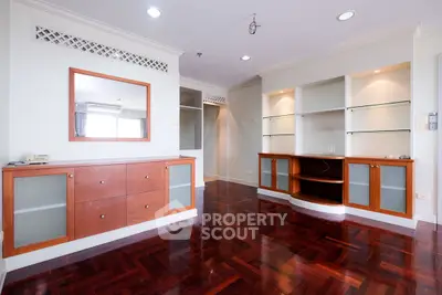 Spacious living room with elegant wooden flooring and built-in cabinets