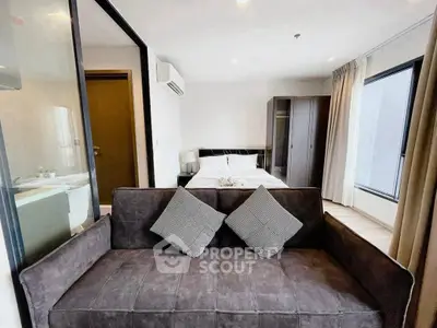 Modern bedroom with stylish sofa and large windows in a contemporary apartment.