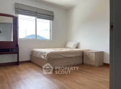 Minimalist bedroom with wooden flooring and natural light