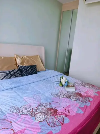 Cozy bedroom with floral bedding and mirrored wardrobe in modern apartment.