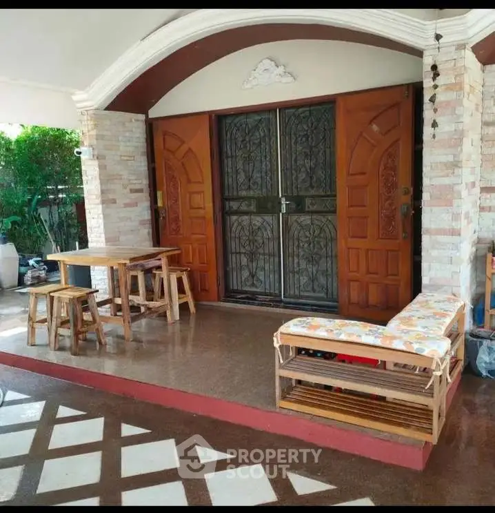 Charming entrance with rustic wooden doors and cozy outdoor seating area.
