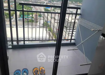 High-rise balcony with city view and drying rack, perfect for urban living.