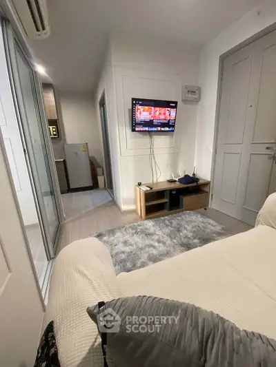 Modern living room with cozy sofa and wall-mounted TV in stylish apartment.