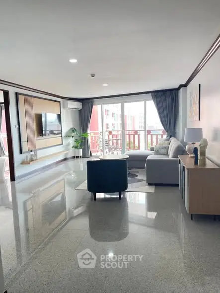 Spacious living room with modern decor and large windows offering city views.