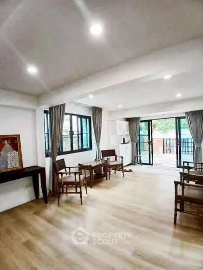 Spacious living room with wooden flooring and large windows for natural light