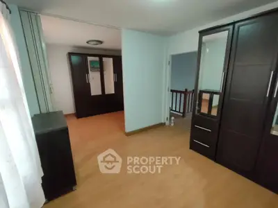 Spacious bedroom with wooden flooring and ample wardrobe space