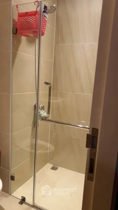 Modern bathroom with glass shower enclosure and beige tiles