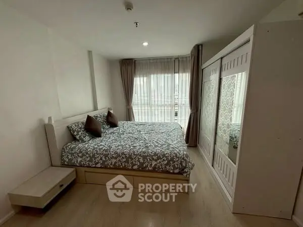 Spacious bedroom with elegant decor and large window for natural light