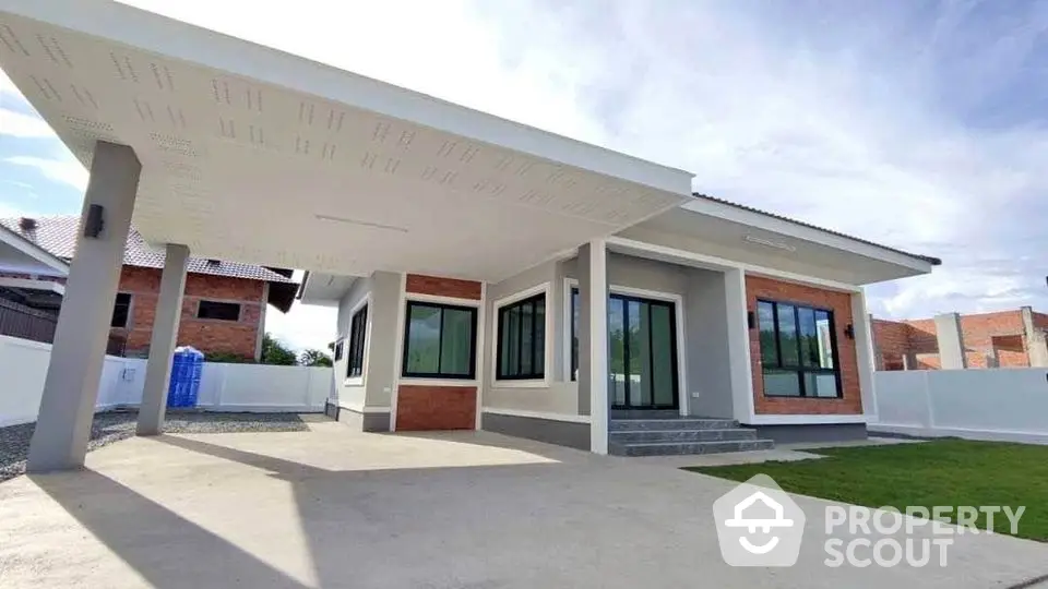 Modern single-story house with spacious driveway and large windows