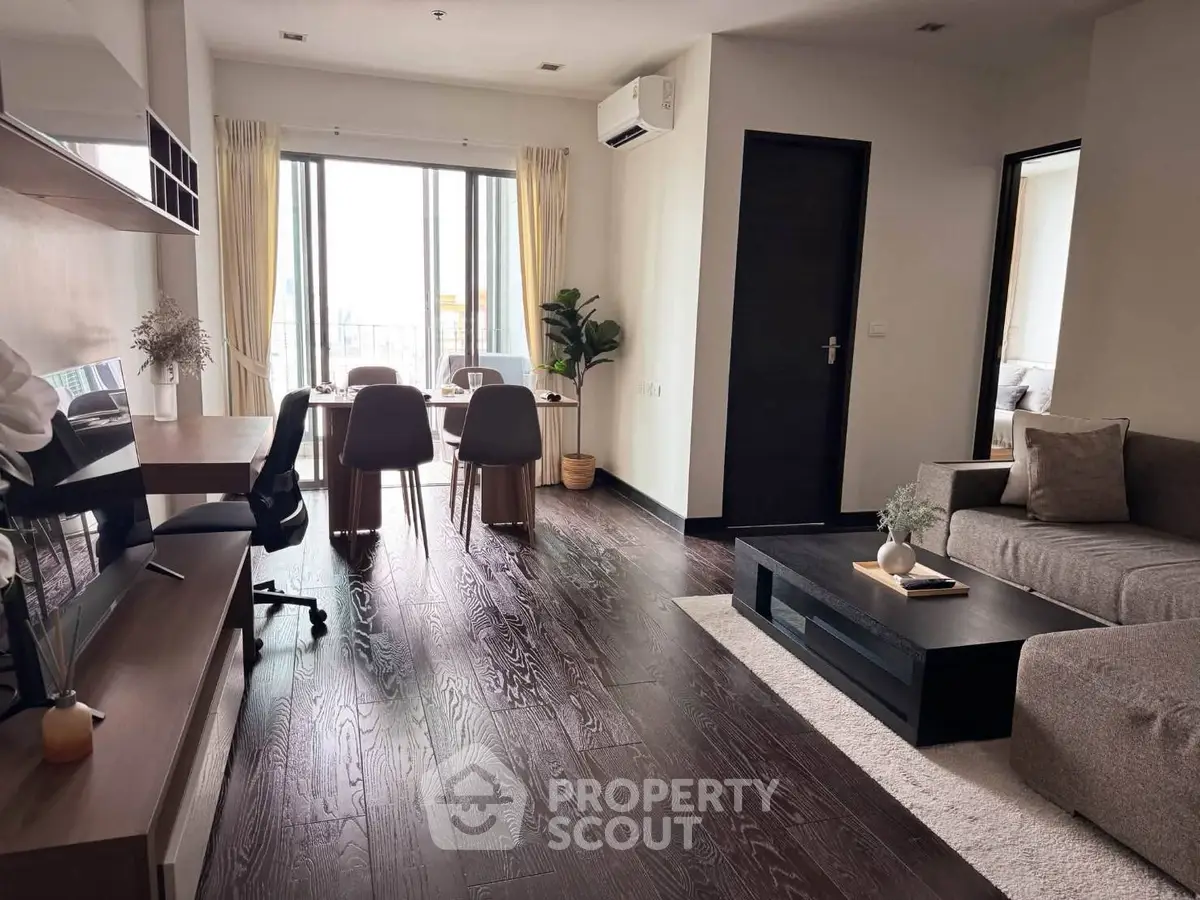 Modern living room with sleek furniture and large windows offering natural light