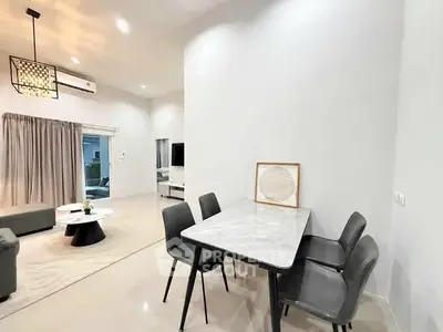 Modern open-plan living and dining area with elegant decor and ample natural light.