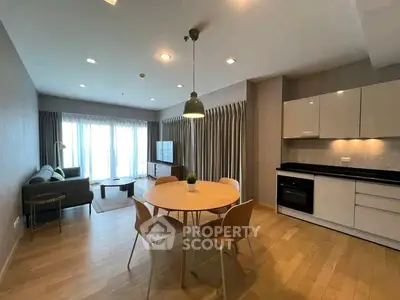 Modern open-plan living room and kitchen with stylish furniture and natural light.