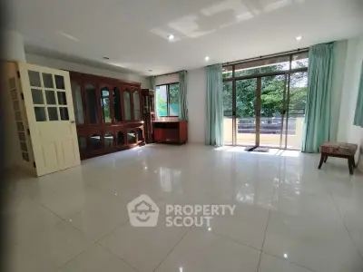 Spacious living room with large windows and elegant wooden cabinet