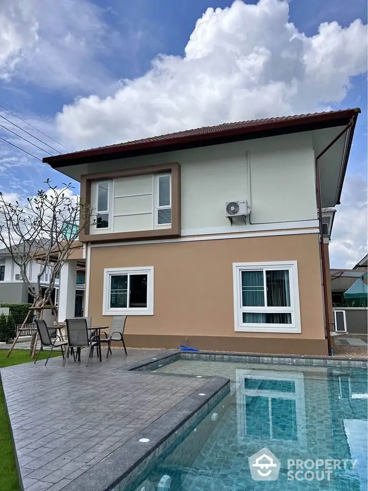 Modern two-story house with pool and outdoor seating area, perfect for family living.