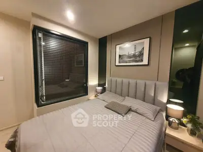 Modern bedroom with stylish decor and large window for natural light.