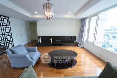 Spacious living room with modern decor and large windows offering city views.