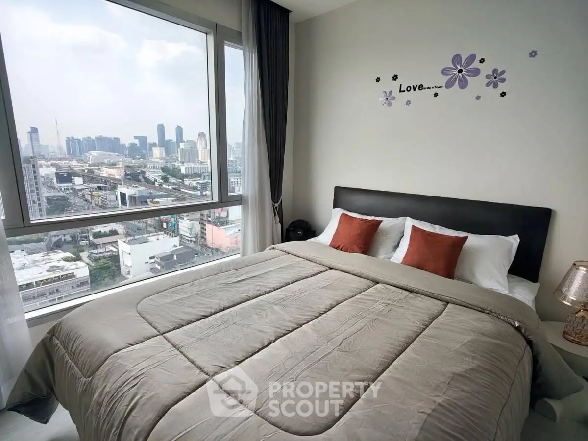 Luxurious bedroom with stunning city view and elegant decor in modern high-rise apartment.