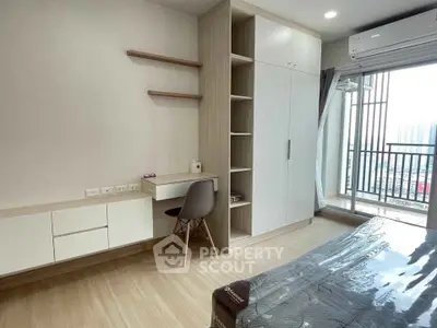 Modern bedroom with balcony view, featuring built-in wardrobe and study desk in a stylish apartment.