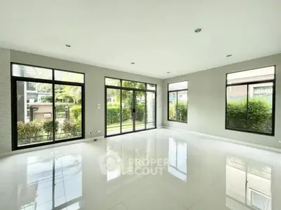 Spacious modern living room with large windows and garden view, perfect for natural light lovers.
