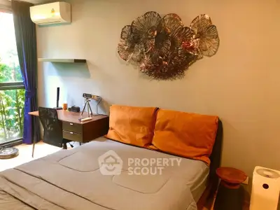 Cozy bedroom with modern decor, featuring a stylish wall art and a functional workspace by the window.