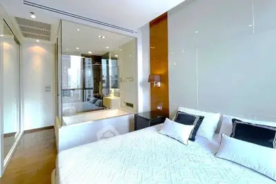 Luxurious bedroom with modern design and bathtub, featuring elegant decor and ample natural light.