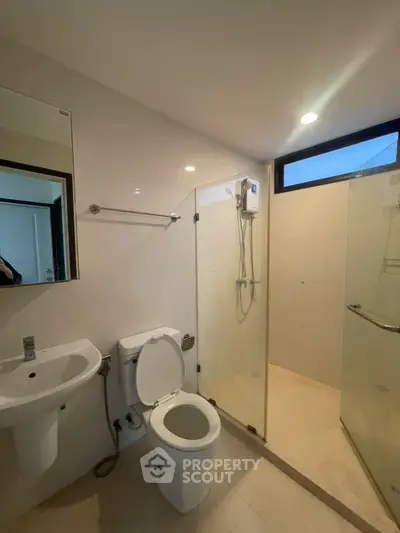 Modern bathroom with glass shower enclosure and sleek fixtures