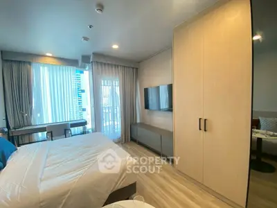 Modern bedroom with large windows and stylish furniture in a high-rise apartment.