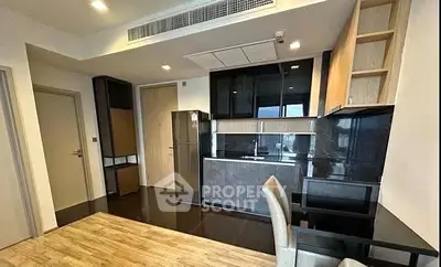 Modern kitchen with sleek black cabinetry and integrated appliances in a stylish apartment.