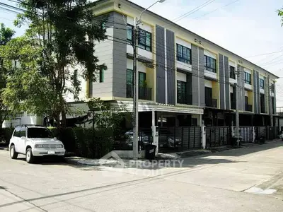 Modern townhouse exterior with multiple floors and parking area