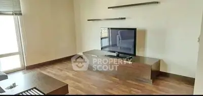 Modern living room with wooden flooring and sleek TV unit