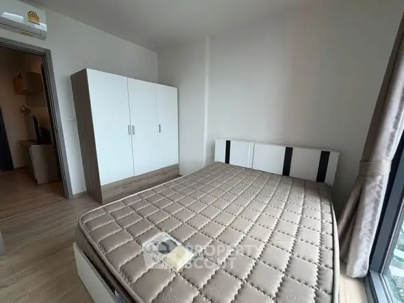 Modern bedroom with large window and stylish wardrobe in a cozy apartment.