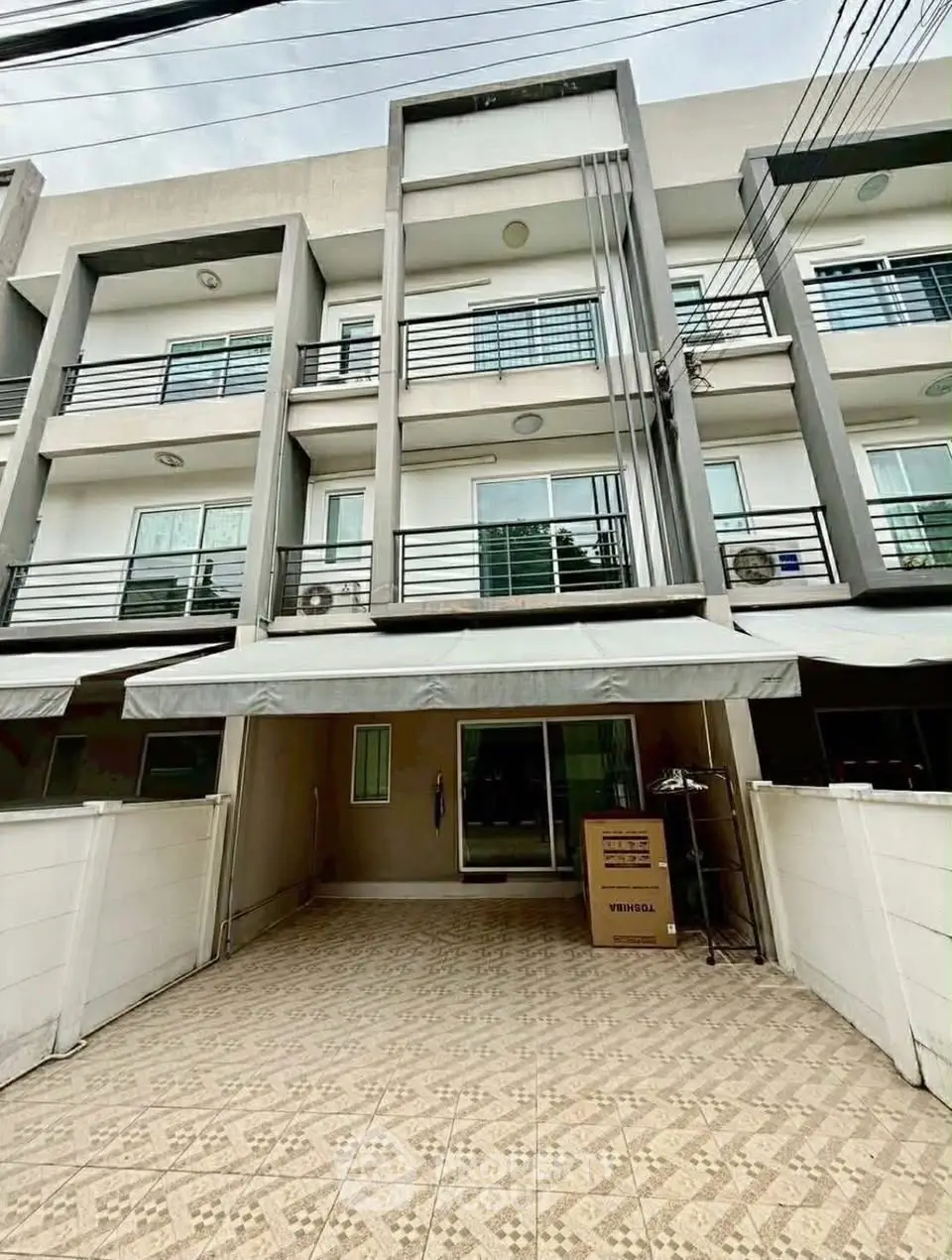 Modern townhouse exterior with spacious driveway and contemporary design.