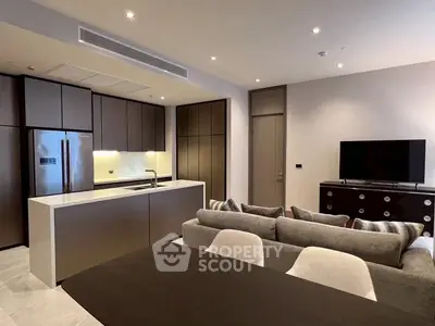 Modern open-plan living room with sleek kitchen and cozy seating area.