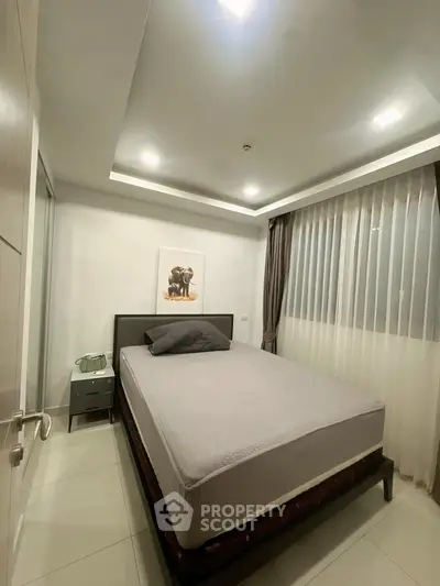 Modern bedroom with cozy bed and stylish decor in a well-lit apartment.