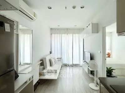Modern living room with sleek design, featuring a cozy sofa, flat-screen TV, and natural light from large windows.