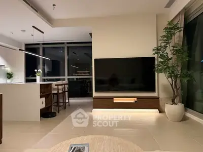 Modern living room with sleek TV setup and stylish kitchen area, perfect for contemporary living.